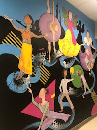 a mural of dancers in a hallway