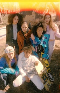 a group of girls with skateboards posing for a photo