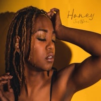 a woman with dreadlocks and a yellow background