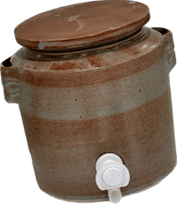 a brown ceramic jug with a lid on it