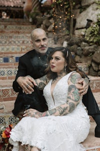 a bride and groom sitting on steps with tattoos