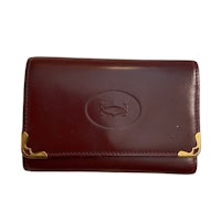 a burgundy leather wallet with gold trim