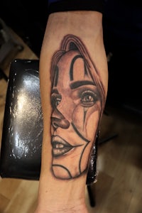 a tattoo of a woman with a clown face