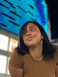 a young woman leaning against a building at night