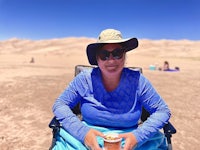 a woman sitting in a chair in the desert