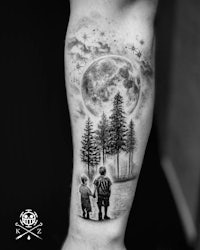 a black and white tattoo of a boy and a tree