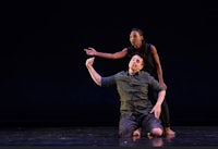 two dancers on a stage with their arms outstretched