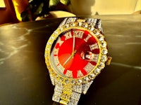 a red and gold watch on a table