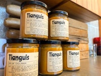 four jars of tanguis chutney sitting on a counter
