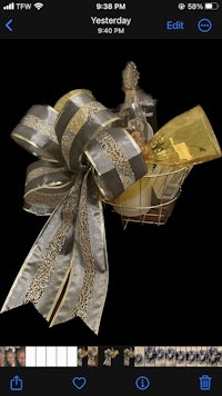 a gold and silver gift basket with a bow