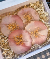 a box with four pink flowers in it