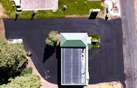 an aerial view of a parking lot and a house