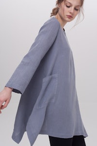 the model is wearing a blue tunic with pockets