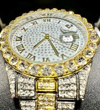 a gold and diamond watch with roman numerals
