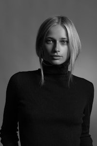 a black and white photo of a woman in a turtle neck sweater