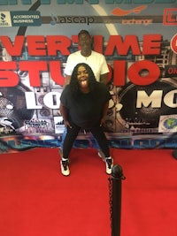 two people posing for a picture in front of the evertime studio sign