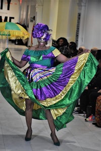 a woman in a mardi gras costume on a runway