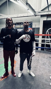 two men standing in a boxing ring
