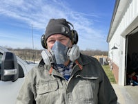 a man wearing a face mask in front of a truck