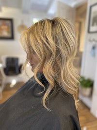 a woman's hair in a salon with long wavy hair