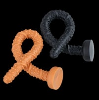 two black and orange rubber sex toys on a black background