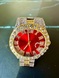 a red and gold watch with diamonds on it