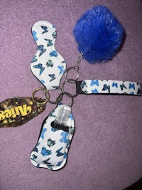 a blue and white keychain with a blue pom pom