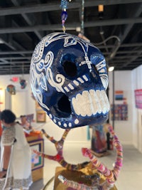 a blue and white sugar skull hanging on a wall