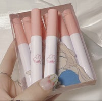 a hand holding a box of pink and white pencils