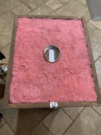 a square of pink foam sitting on a tile floor