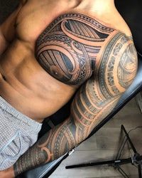 a man with a tribal tattoo on his chest
