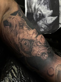 a tattoo of a rhino on a man's arm