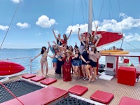 a group of women posing on the deck of a catamaran