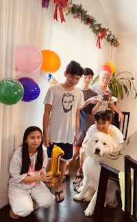 a group of people posing with a dog and balloons