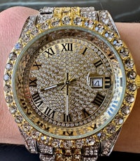 a gold and diamond watch on a person's wrist