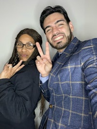 two people making a peace sign in front of a camera