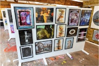 a display of framed pictures in an art studio