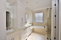 a white bathroom with a tub and sink