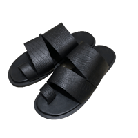 a pair of black slide sandals on a black background
