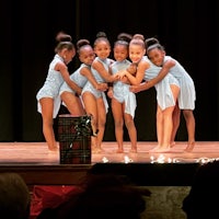 a group of young dancers posing on stage