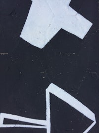 a black and white arrow painted on a sidewalk
