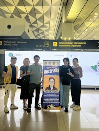a group of people posing for a photo in an airport
