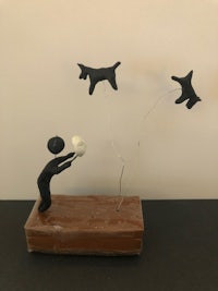 a sculpture of a man and a dog flying in the air