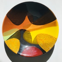 a plate with a yellow, orange, and black design
