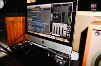 a computer monitor is sitting on a desk in a recording studio