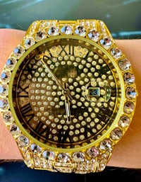 a person wearing a gold watch with diamonds on it
