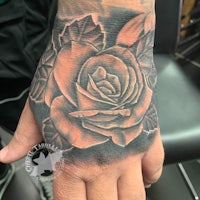 a hand with a rose tattoo on it