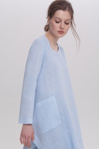 a model wearing a blue linen tunic with pockets