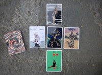 four tarot cards laying on the ground