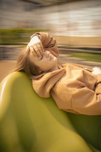 a woman laying on a green chair